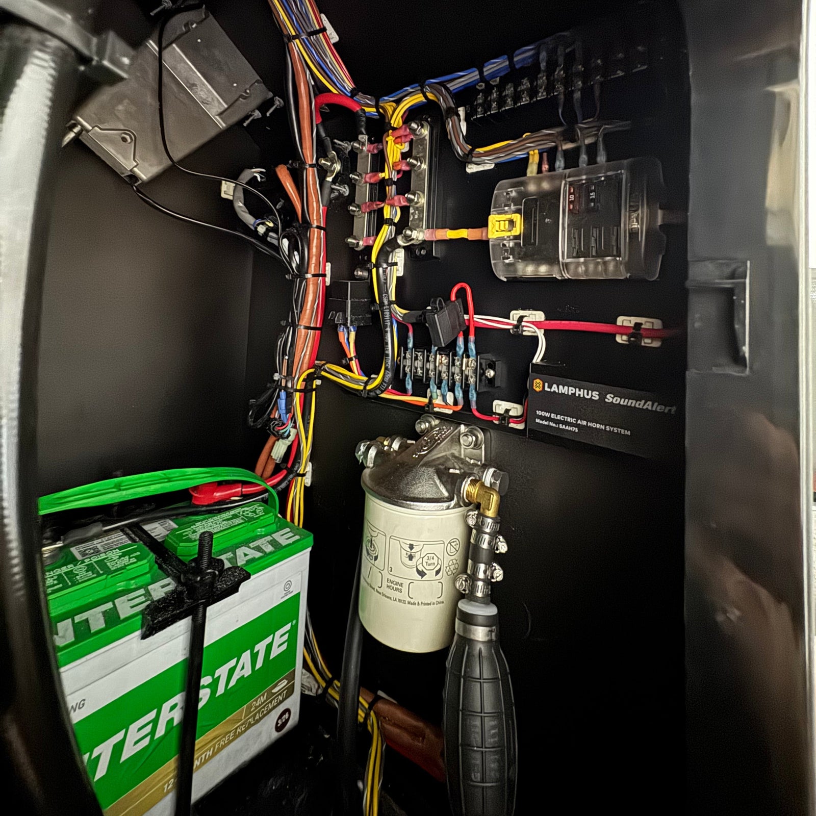 Close-up of TOUGH BOAT'S electrical system with wiring and components.